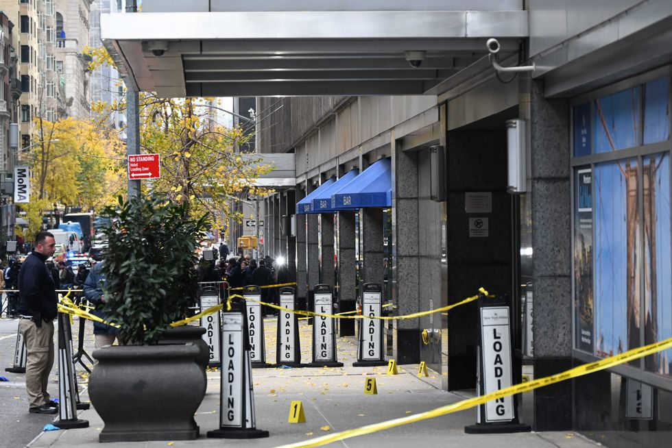 Police officers investigate the scene where UnitedHealthcare CEO Brian Thompson was fatally shot in Midtown Manhattan near the New York Hilton on 54th Street between 6th and 7th avenues on Dec. 4, 2024