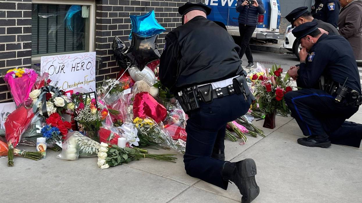 Police officers mourn at a makeshift memorial for Temple University police officer Christopher Fitzgerald, who was killed in the line of duty Saturday night near the campus.