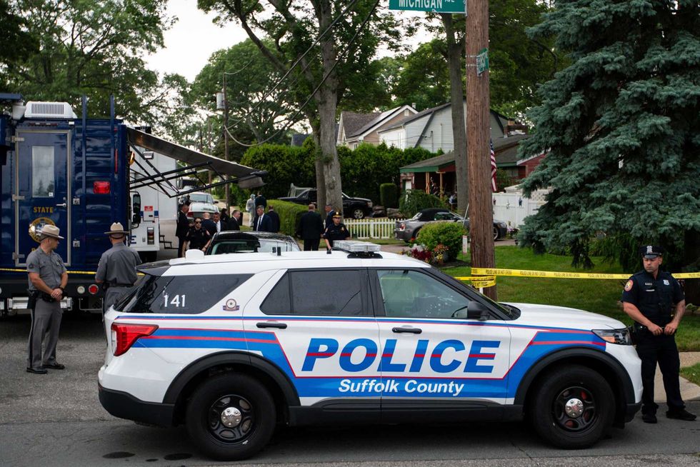 Police officers stand guard near the house on First Avenue in Massapequa Park, where investigators were searching on July 14, 2023