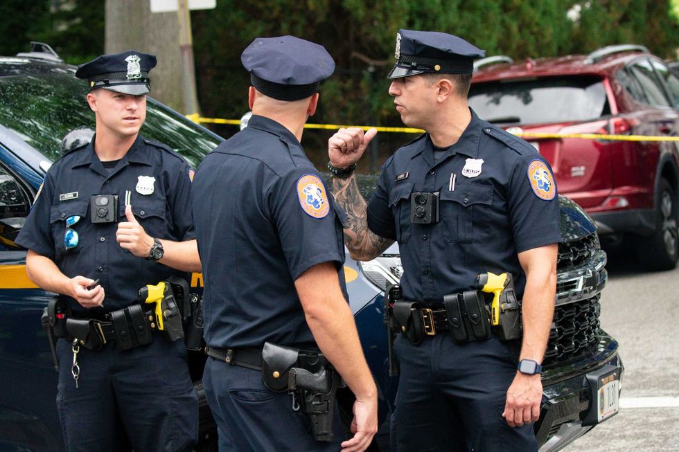 Police officers stand guard near the house where a suspect has been taken into custody on New York