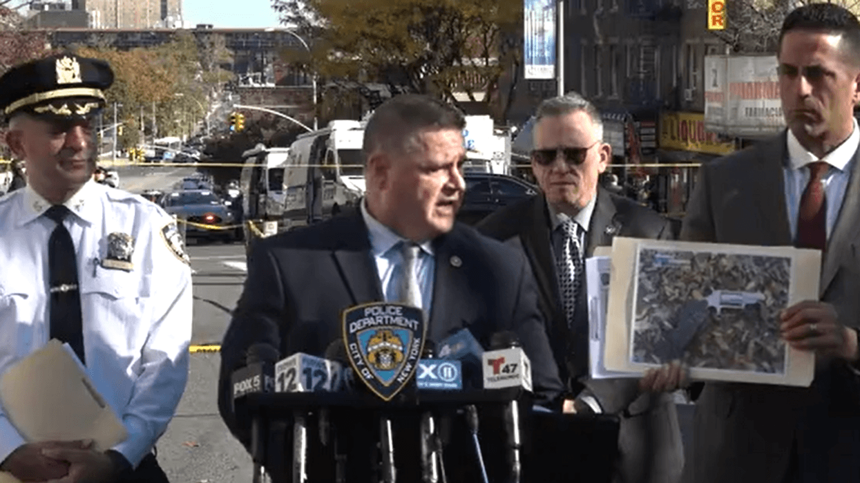 Police officials hold up an image of the gun they say officers recovered at the scene of the shooting.