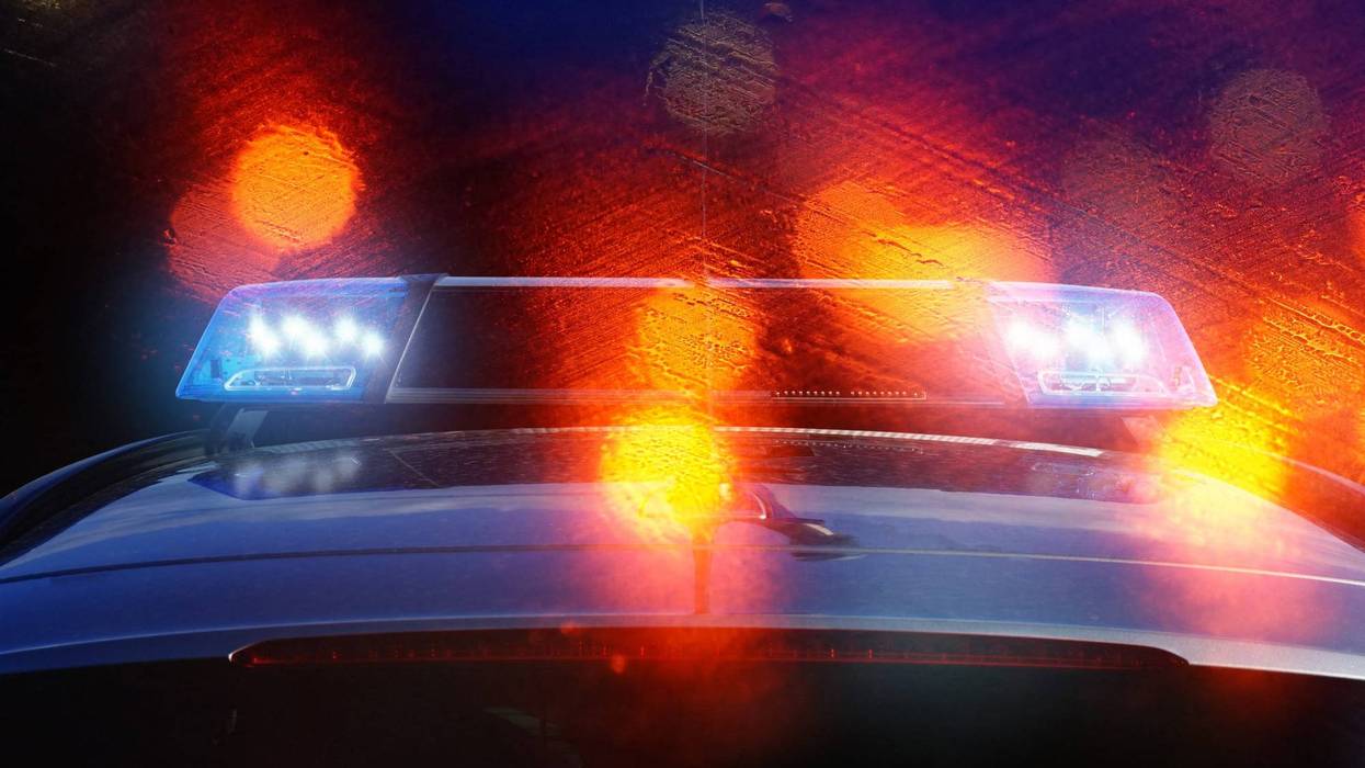 police patrol car on the road at night with flashing blue lights and backlights from other vehicles