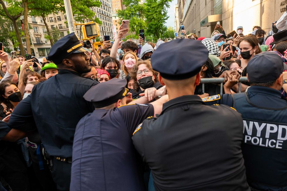 Police push back protesters as they gather outside of Columbia University