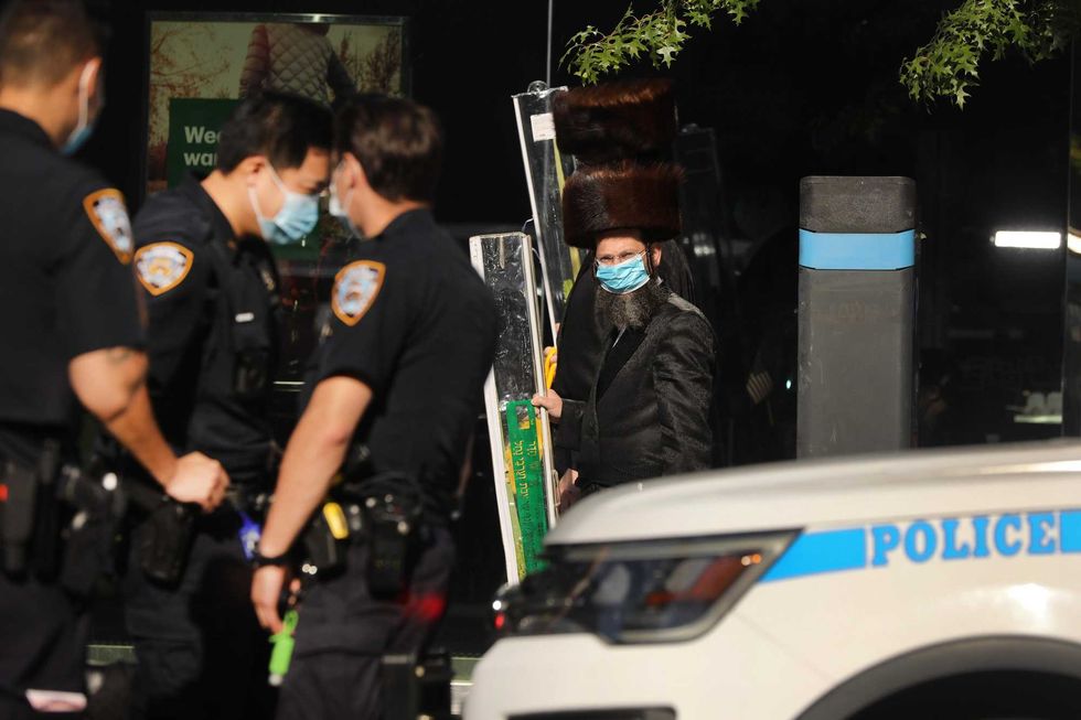 Police stand guard after a night of protests in the Brooklyn neighborhood of Borough Park on October 07, 2020 in New York City.