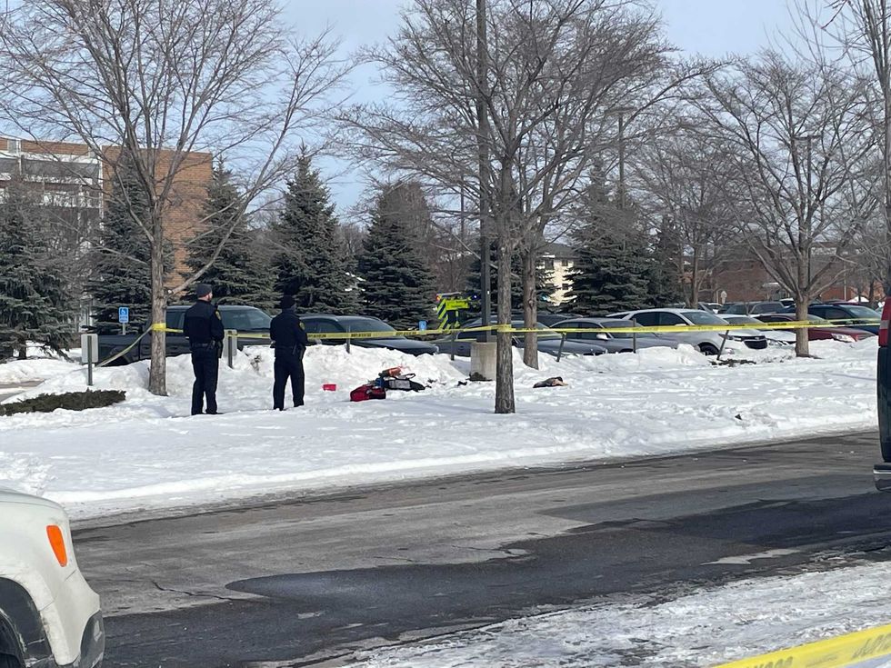 Police standing in front of a marked off section of the sidewalk.