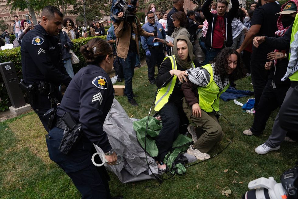 police taking tent from two people in neon vests