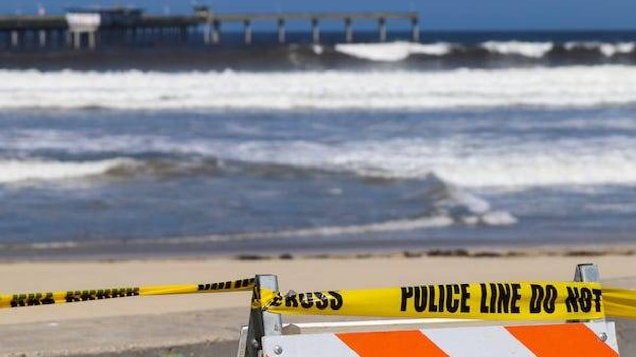 Police tape blocking off a beach