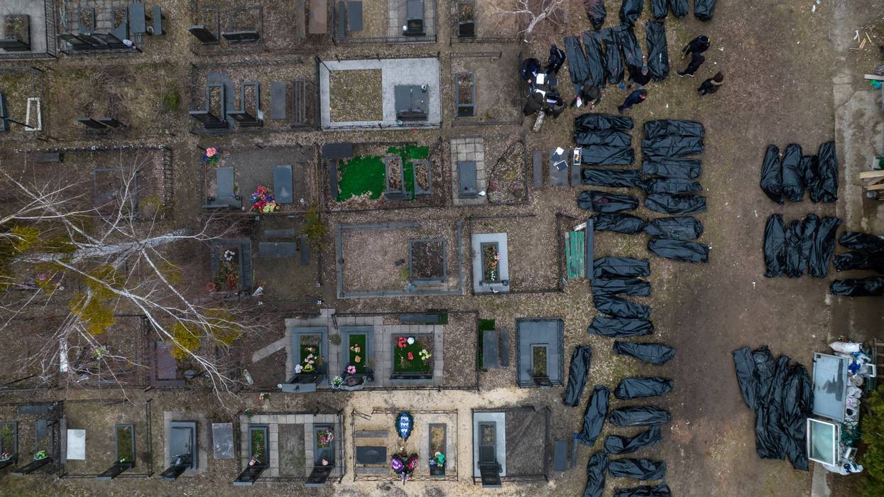 Policemen work to identify civilians who were killed during the Russian occupation in Bucha, Ukraine, on the outskirts of Kyiv, before sending the bodies to the morgue, Wednesday, April 6, 2022.