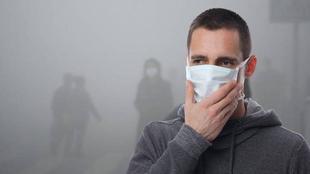Portrait of man wearing facial hygienic mask outdoors. Ecology, air pollution, Environmental awareness and virus protection concept