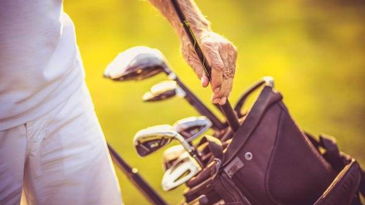 Portrait of senior golfer standing on court