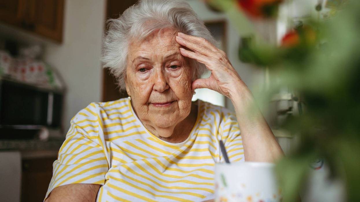 Portrait of worried senior woman crying in kitchen.