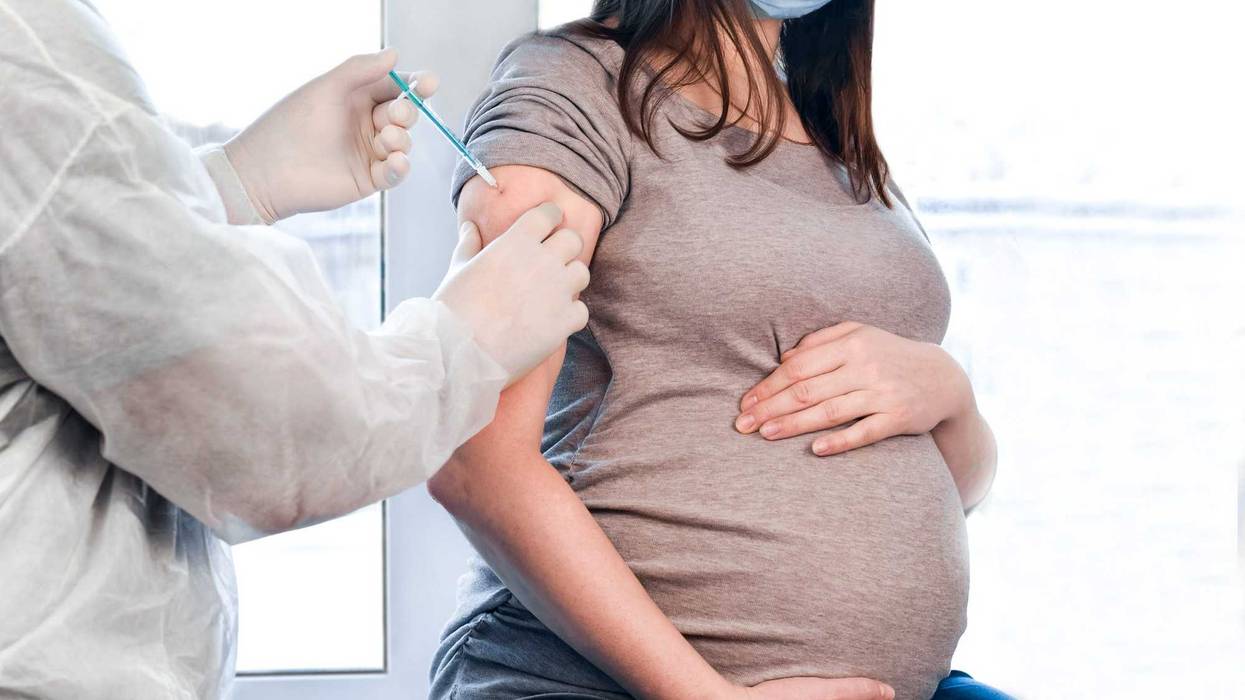 Pregnant woman getting vaccinated stock photo.