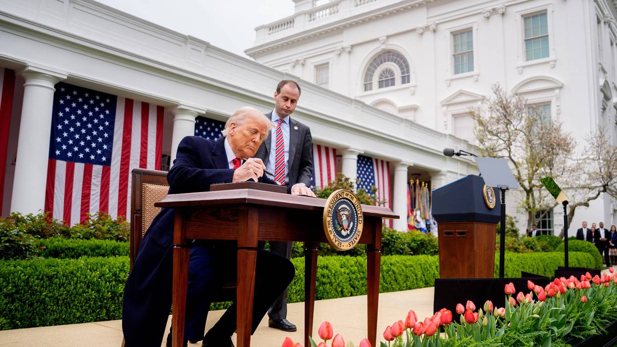 President Donald Trump, accompanied by White House staff secretary Will Scharf, signs executive orders imposing tariffs on imported goods during a "Make America Wealthy Again" trade announcement event in the Rose Garden at the White House on April 2, 2025, in Washington, DC.