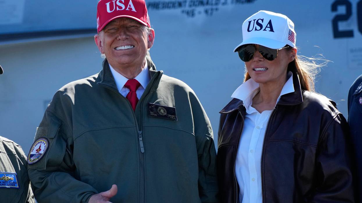 President Donald Trump and first lady Melania Trump pose in front of a F/A-18E fighter jet with President Donald Trump's name on it, as part of the Navy's 250th anniversary celebration, aboard the USS George H.W. Bush aircraft carrier in the Atlantic Ocean off the coast of Norfolk, Va., Sunday, Oct. 5, 2025.