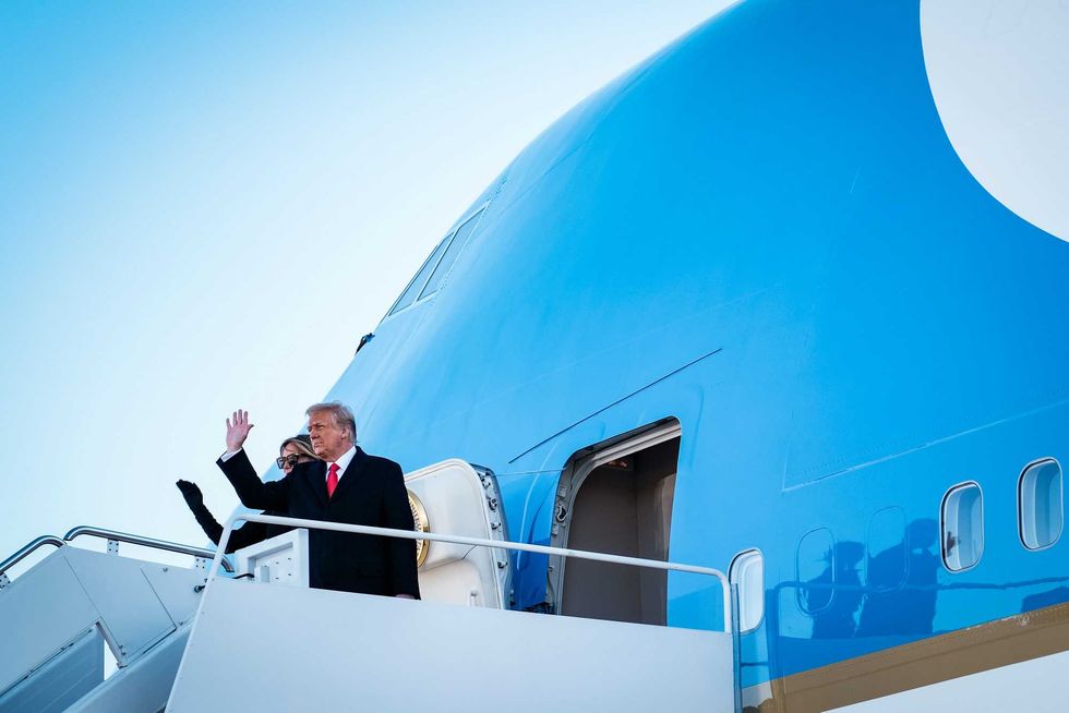 President Donald Trump and first lady Melania Trump wave to supporters as they board Air Force One to head to Florida on January 20, 2021 in Joint Base Andrews, Maryland.