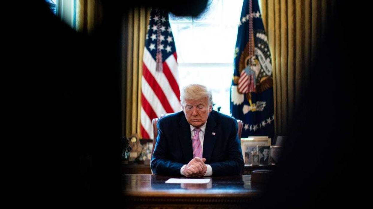 President Donald Trump bows his head during a Easter blessing by Bishop Harry Jackson, senior pastor at Hope Christian Church in Beltsville, Md., in the Oval Office of the White House on April 10, 2020 in Washington, DC.