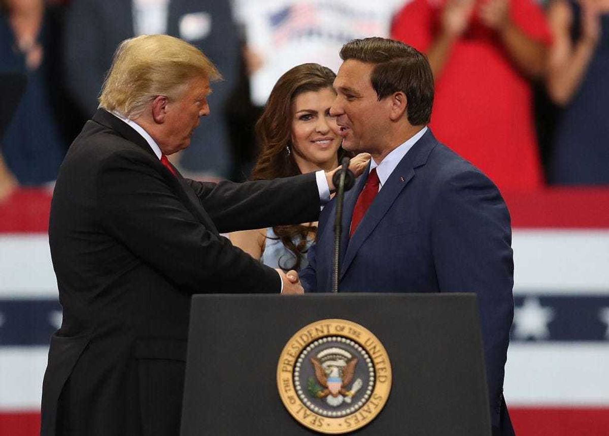 President Donald Trump greets Florida Republican gubernatorial candidate Ron DeSantis as his wife, Casey DeSantis, looks on as they are introduced during a campaign rally at the Hertz Arena on October 31, 2018 in Estero, Florida. President Trump continues travelling across America to help get the vote out for Republican candidates running for office. (Photo by Joe Raedle/Getty Images)