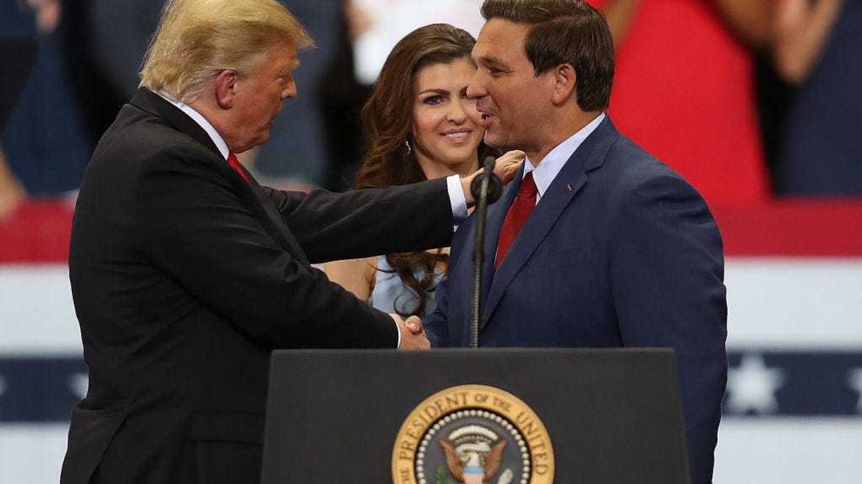 President Donald Trump greets Florida Republican gubernatorial candidate Ron DeSantis as his wife, Casey DeSantis, looks on as they are introduced during a campaign rally at the Hertz Arena on October 31, 2018 in Estero, Florida. President Trump continues travelling across America to help get the vote out for Republican candidates running for office. (Photo by Joe Raedle/Getty Images)