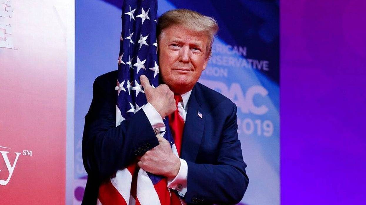 President Donald Trump hugs the American flag as he arrives to speak at Conservative Political Action Conference, CPAC 2019, in Oxon Hill, Md., Saturday, March 2, 2019.