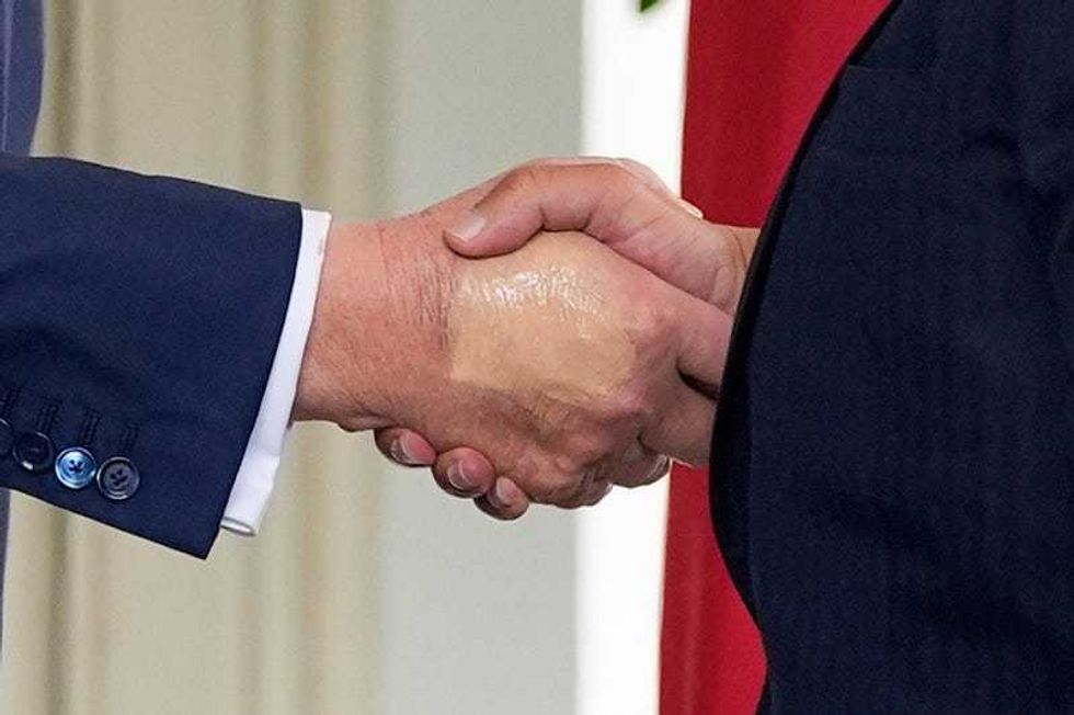 President Donald Trump, left, greets Bahrain