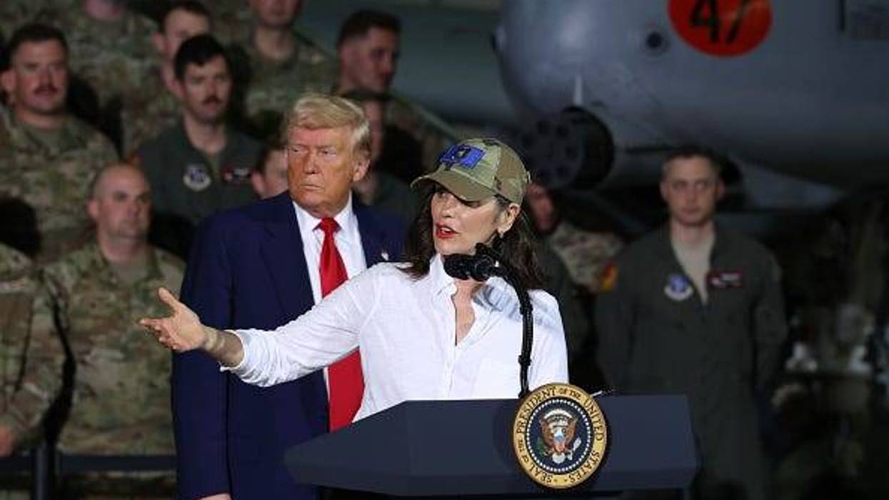 President Donald Trump listens as Michigan Gov. Gretchen Whitmer speaks at Selfridge Air National Guard Base.