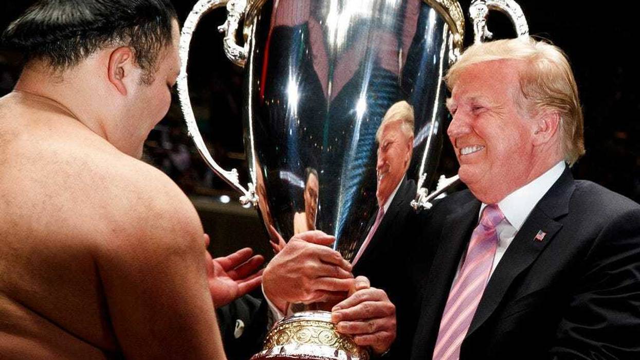 President Donald Trump presents the "President's Cup" to Tokyo Grand Sumo Tournament winner Asanoyama, at Ryogoku Kokugikan Stadium, Sunday, May 26, 2019, in Tokyo.