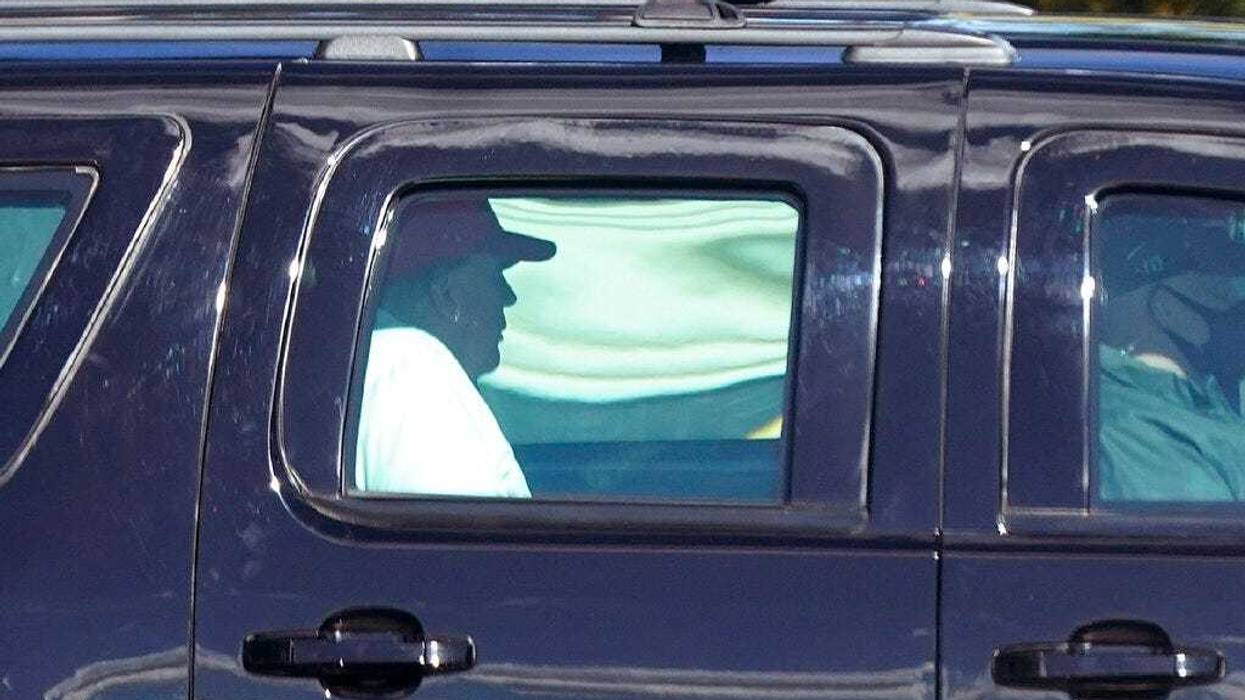 President Donald Trump rides in a motorcade vehicle as he departs Trump International Golf Club, Sunday, Dec. 27, 2020, in West Palm Beach, Fla. (AP Photo/Patrick Semansky)