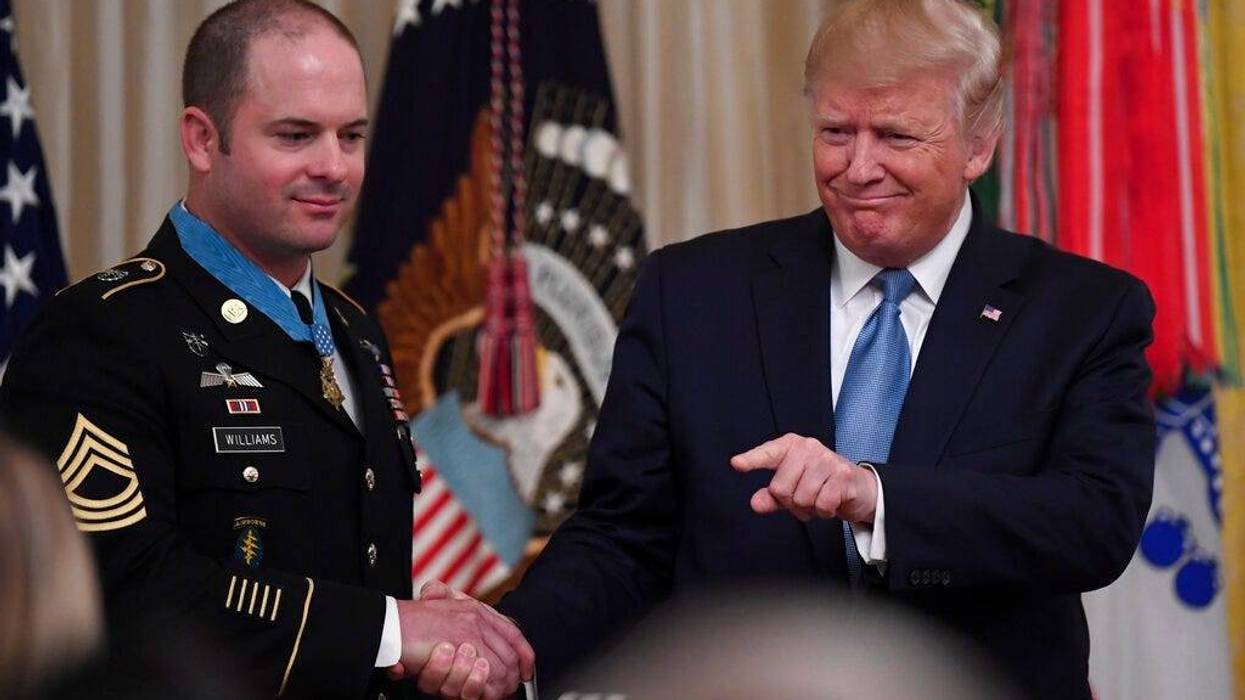 President Donald Trump, right, shakes hands with U.S. Army Master Sgt. Matthew Williams, left, currently assigned to the 3rd Special Forces Group