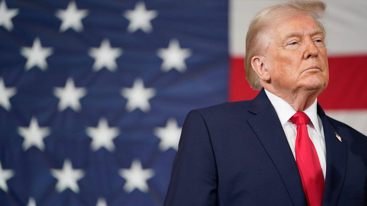 President Donald Trump standing in front of an American flag