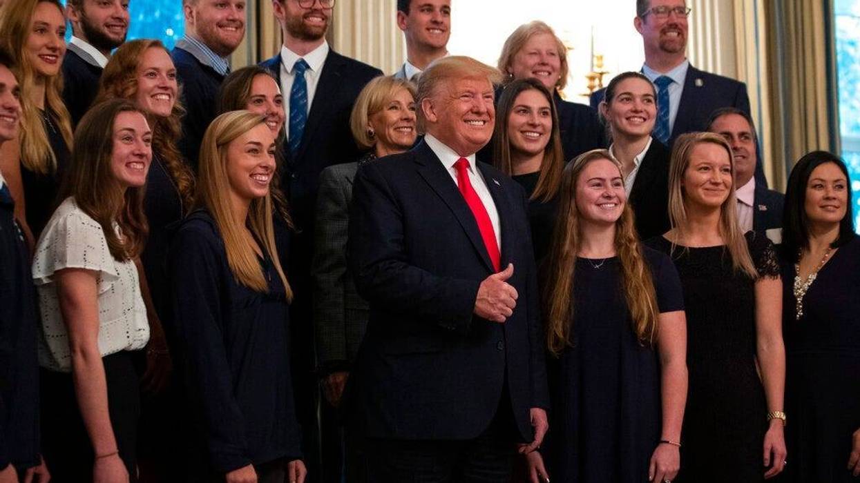 President Donald Trump stands with members of Queens University of Charlotte Swim Team during the NCAA Collegiate National Champions Day at the White House, Friday, Nov. 22, 2019, in Washington.