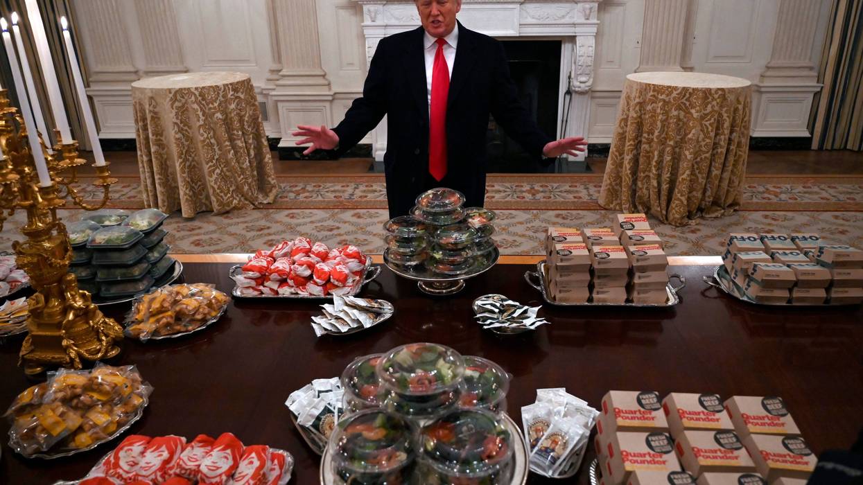 President Donald Trump talks to the media about the table full of fast food in the State Dining Room of the White House