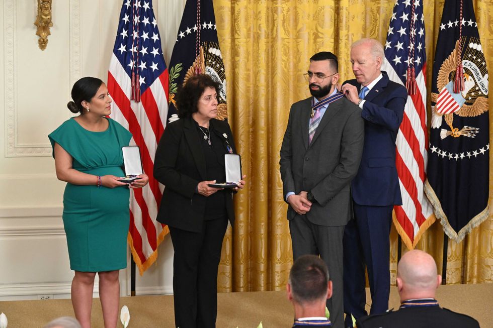 President Joe Biden awards the Medal of Valor to (L-R) Dominique Rivera, the wife of fallen NYPD Detective Jason Rivera; Gabina Mora, the mother of fallen NYPD Detective Wilbert Mora; and NYPD Detective Sumit Sulan in the East Room of the White House in Washington, DC, on May 17, 2023