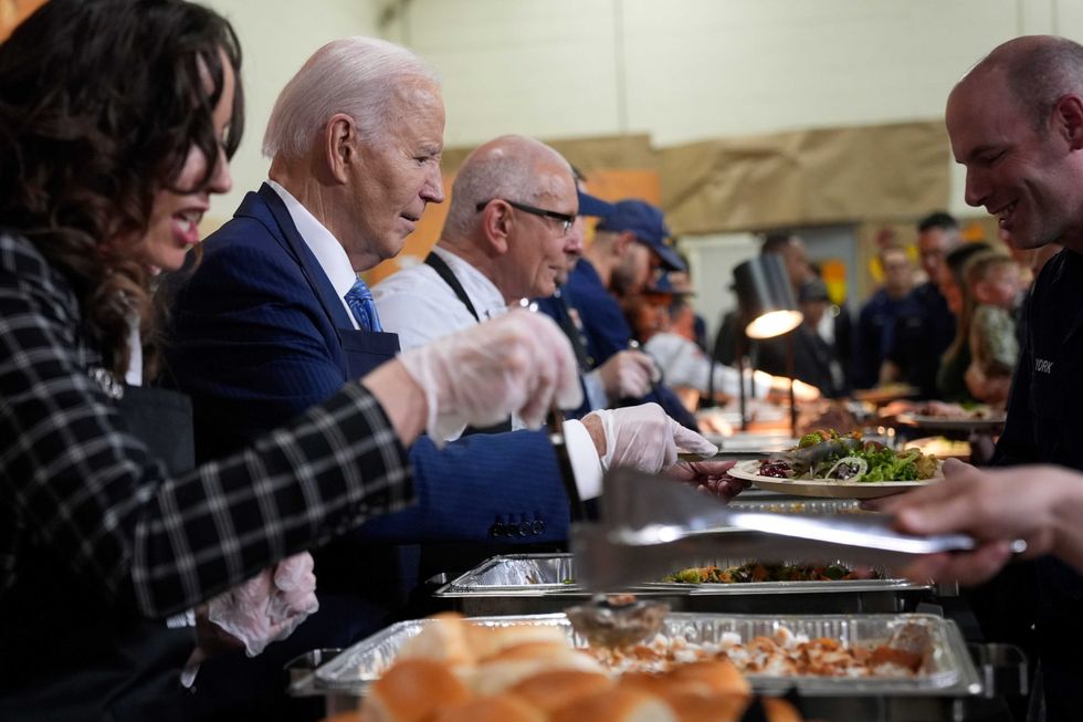 President Joe Biden, from second left, and chef Robert Irvine serve food at a Friendsgiving event with service members and their families in the Staten Island borough of New York, Monday, Nov. 25 2024