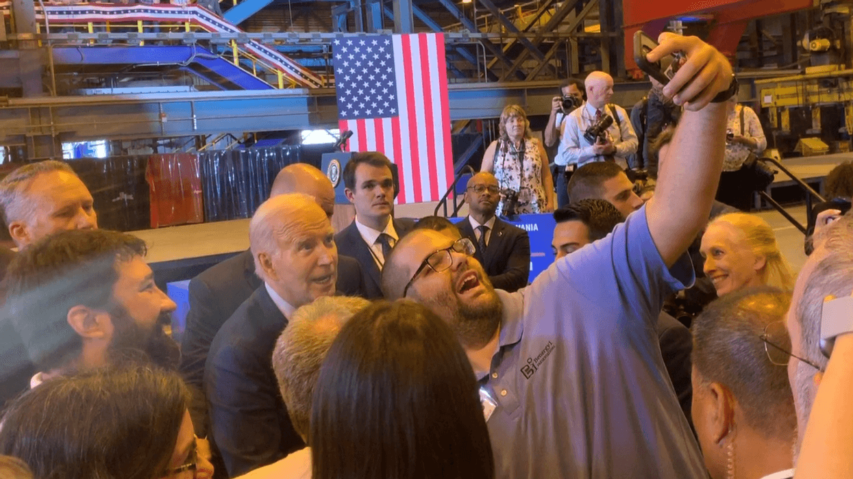 President Joe Biden pauses to take a selfie at Philly Shipyard after announcing the a contract to build a first-of-its-kind ship that will support construction of off-shore wind energy farms.