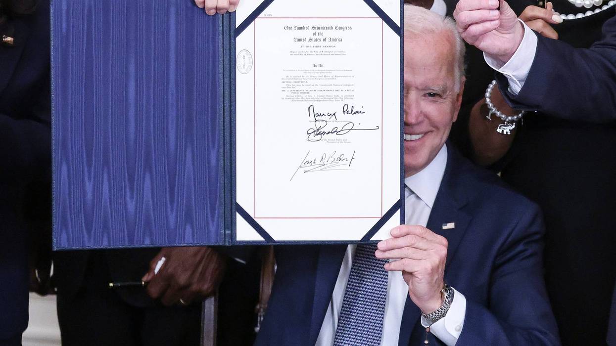 President Joe Biden (right) holds a signed Juneteenth National Independence Day Act into law in the East Room of the White House on June 17, 2021 in Washington, DC.
