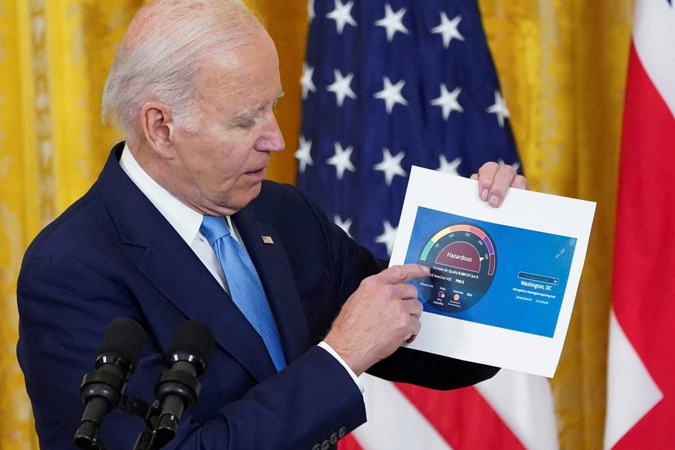 President Joe Biden shows an air quality chart regarding smoke in the air from Canadian wildfires during a joint press conference in the East Room at the White House