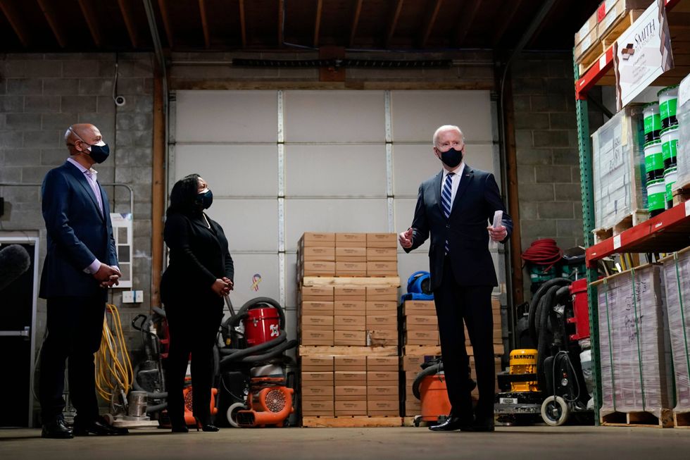 President Joe Biden speaks with owners Kristin Smith and James Smith as he visits Smith Flooring in Chester, Pa., Tuesday, March 16, 2021.