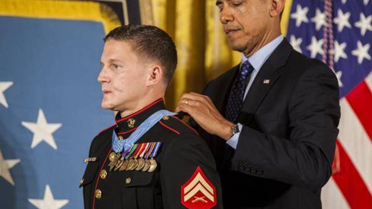 President of the United States, Barrack H. Obama places the Medal of Honor around retired U.S. Marine Corps Cpl. William Kyle Carpenter's neck, inside the East Wing of the White House, June 19, 2014.