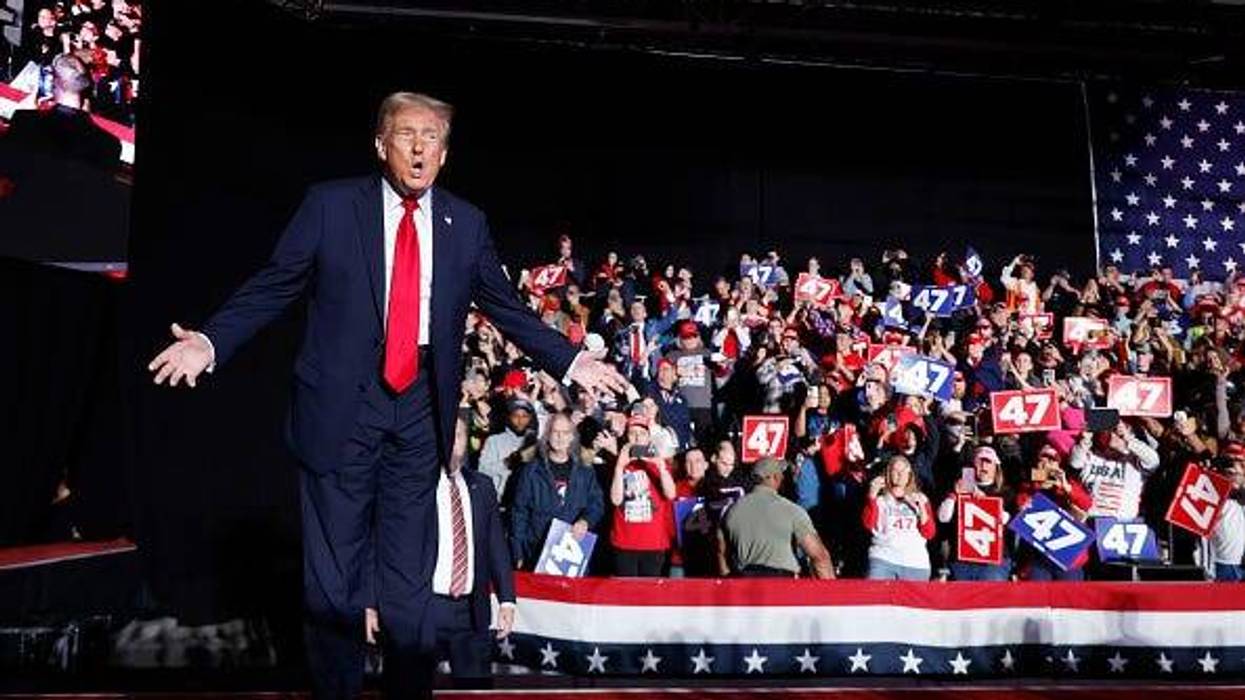 Presidential Candidate Trump stands in front of a crowd of supporters at a 2024 Michigan campaign rally