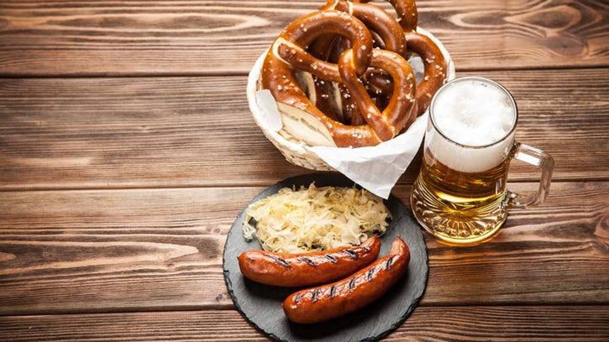 Pretzels, bratwurst and sauerkraut on wooden table