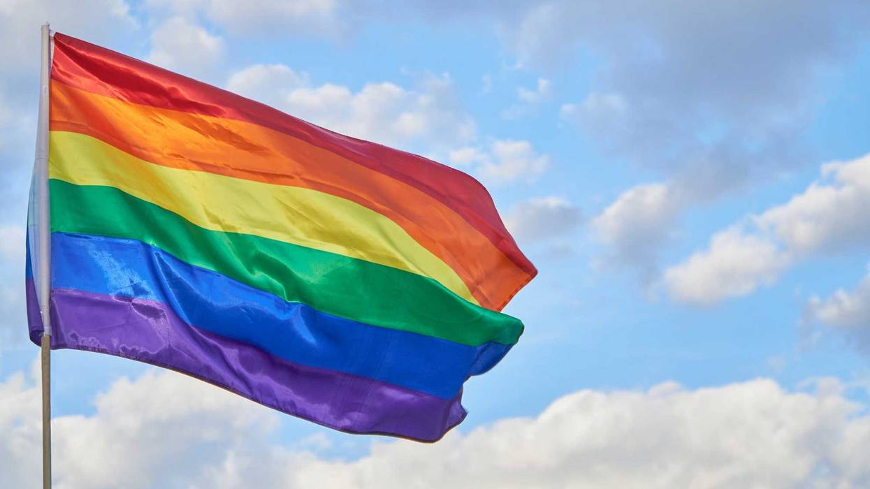 Pride flag flying on a flag pole.