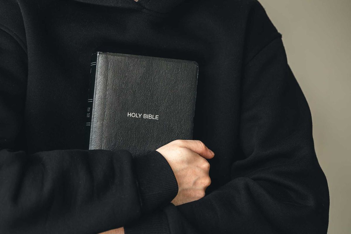 Priest holding Bible.
