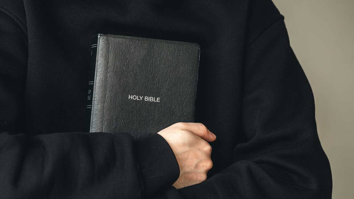 Priest holding Bible.