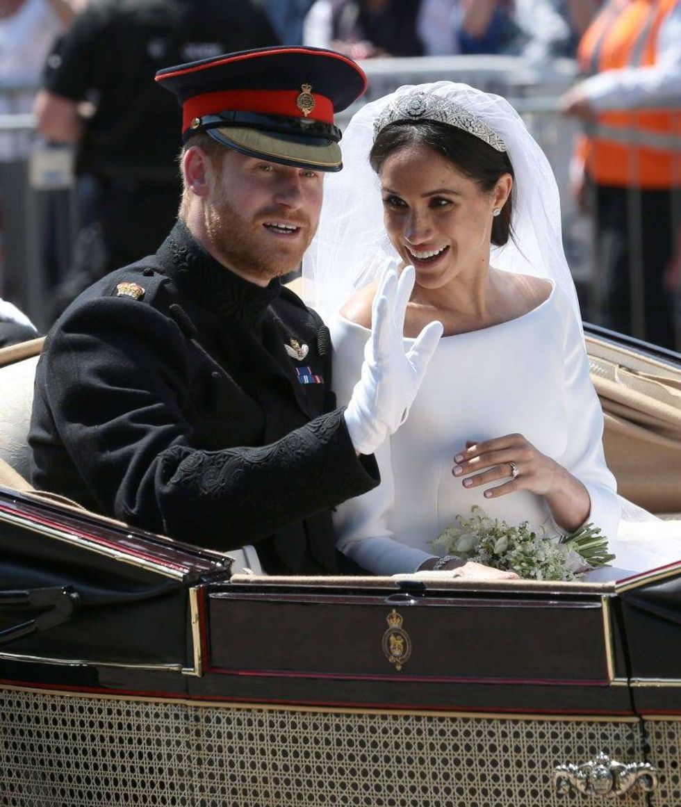 Prince Harry and Meghan Markle wave during their carriage procession on Castle Hill outside Windsor Castle on May 19, 2018 after their wedding ceremony.