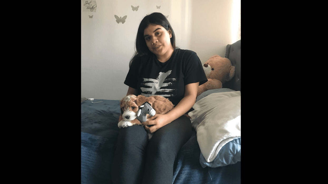 Priscilla Aguirre cuddles with Nico, the labradoodle puppy she received from the Make-A-Wish Foundation