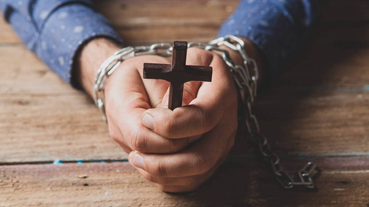 prisoner in chains praying powers cross