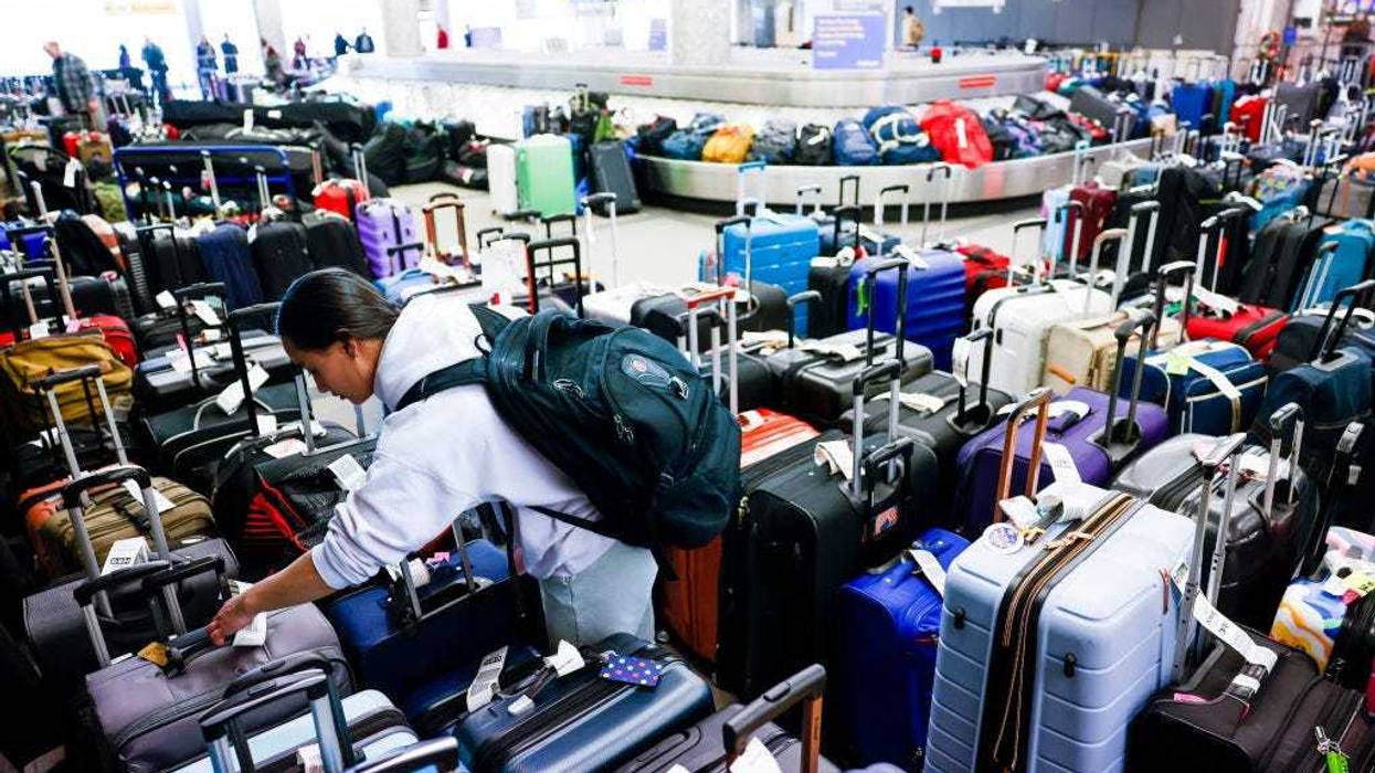 Pristine Floyde searches for a friend's suitcase in a baggage holding area for Southwest Airlines at Denver International Airport on December 28, 2022 in Denver, Colorado. More than 15,000 flights have been canceled by airlines since winter weather began impacting air travel on December 22. (Photo by Michael Ciaglo/Getty Images)