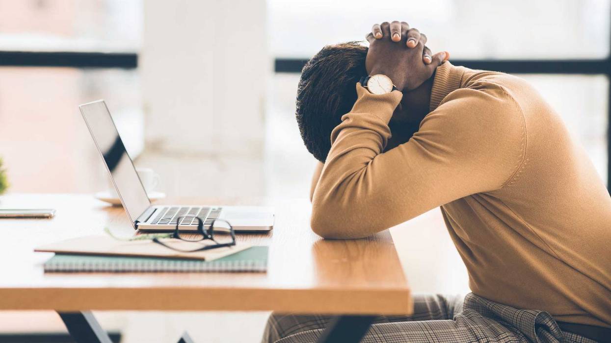 Problems At Work. Black businessman feeling upset and desperate, working at office, hands on head. Free space