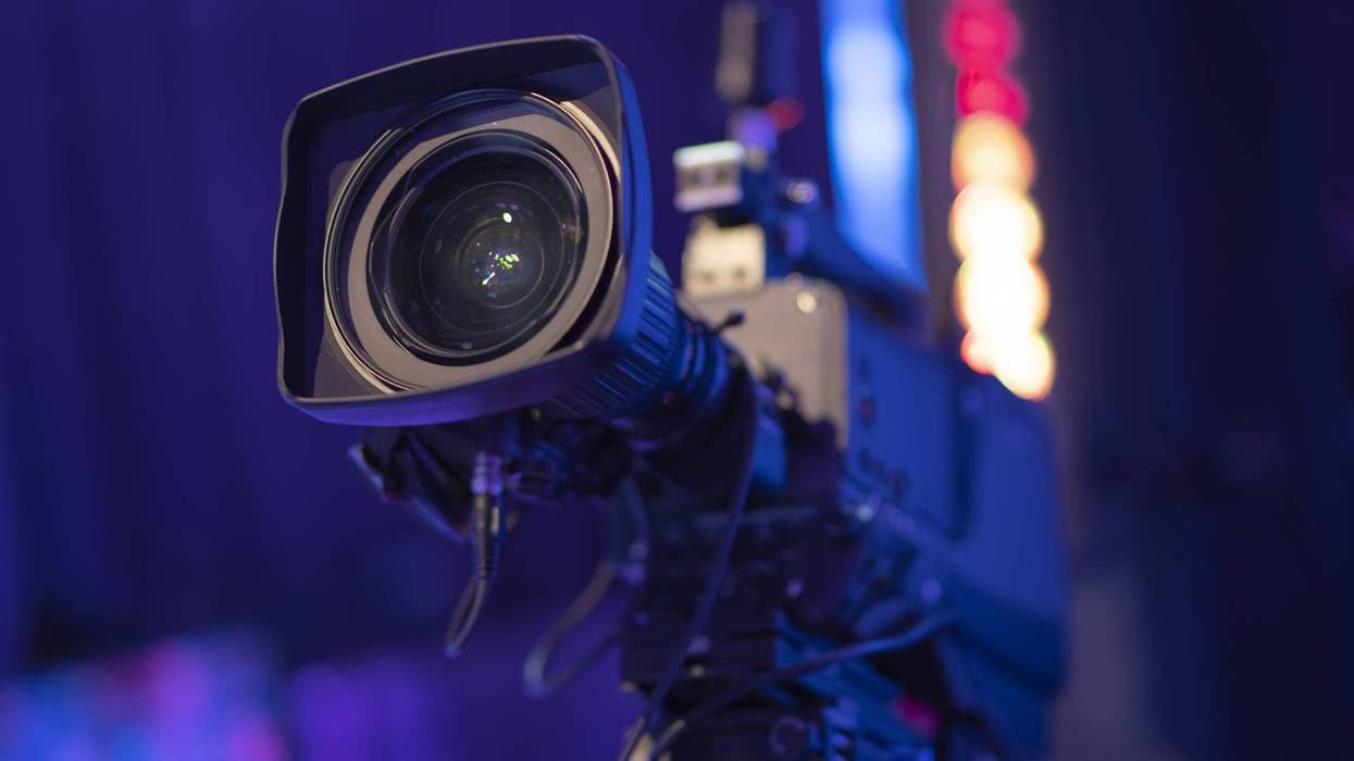 Professional broadcasting video camera in studio with colorful bokeh with copy space