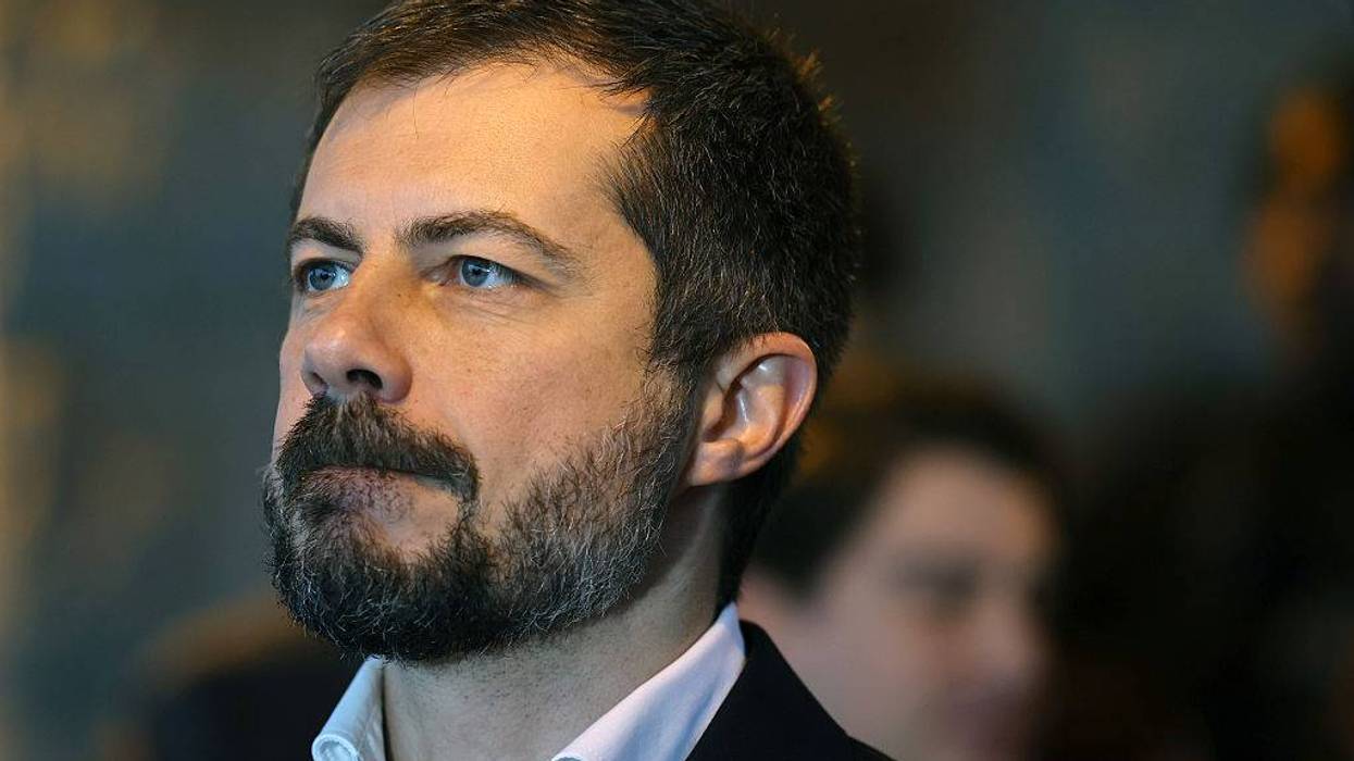 Profile of a dark-haired, bearded man with blue eyes, looking intently to the left.